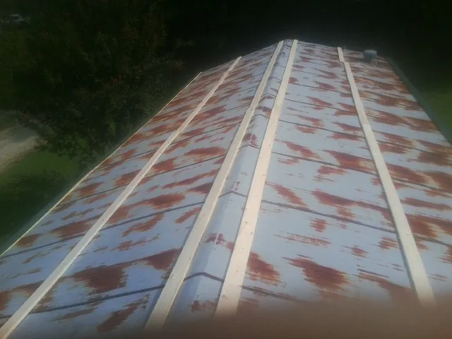 Rusted metal roof panels with new wood purlins before replacement — Storm Damage Roof Repair in Clark by Roofing Brothers